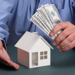 parts of hands with house and money
