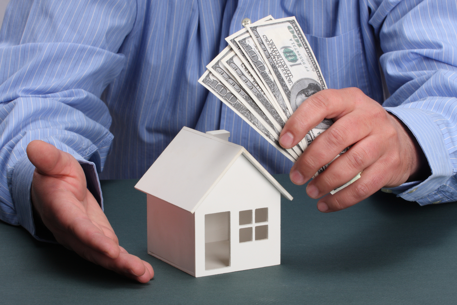 parts of hands with house and money
